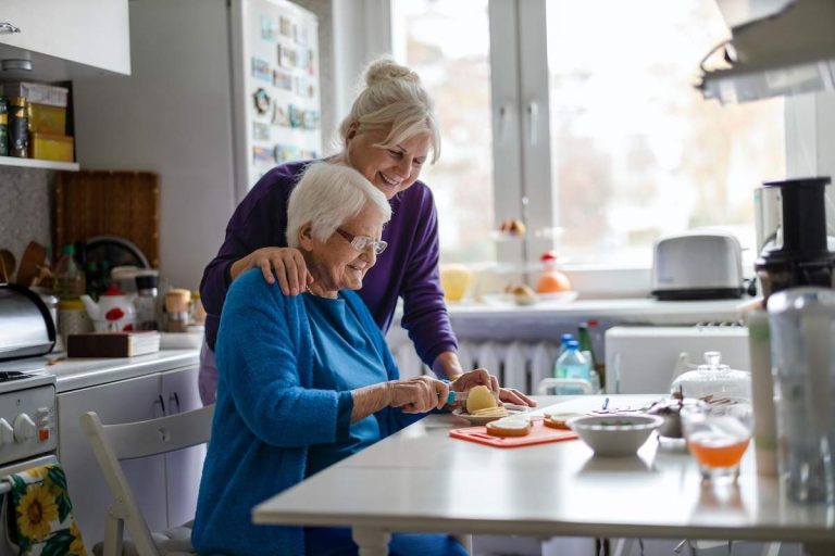 Woman spending time with her elderly mother at home while meal prepping.