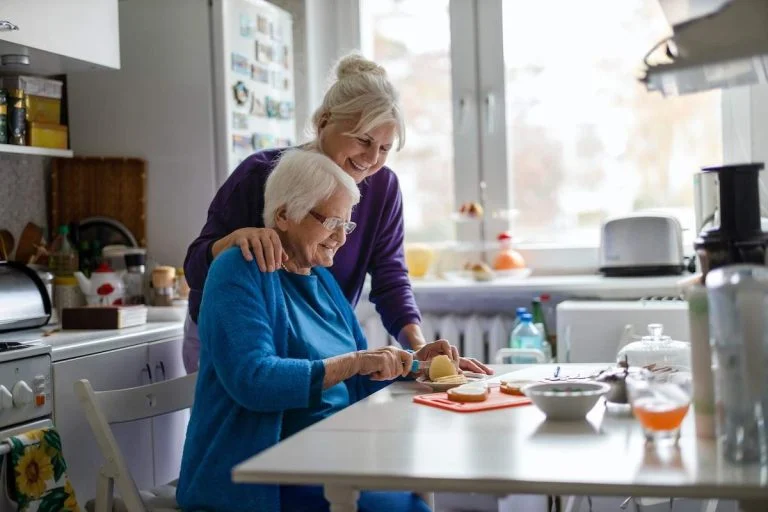 Woman spending time with her elderly mother at home while meal prepping.
