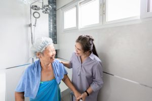 Caregiver helping an older woman with bathing.