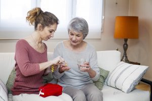 Caregiver Helping Older Woman with Medication Management