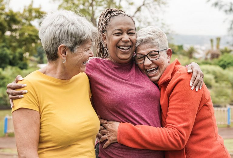 Group of senior ladies hugging each other.