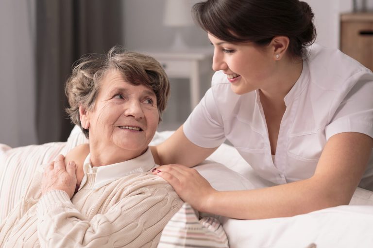 Caregiver comforting older woman