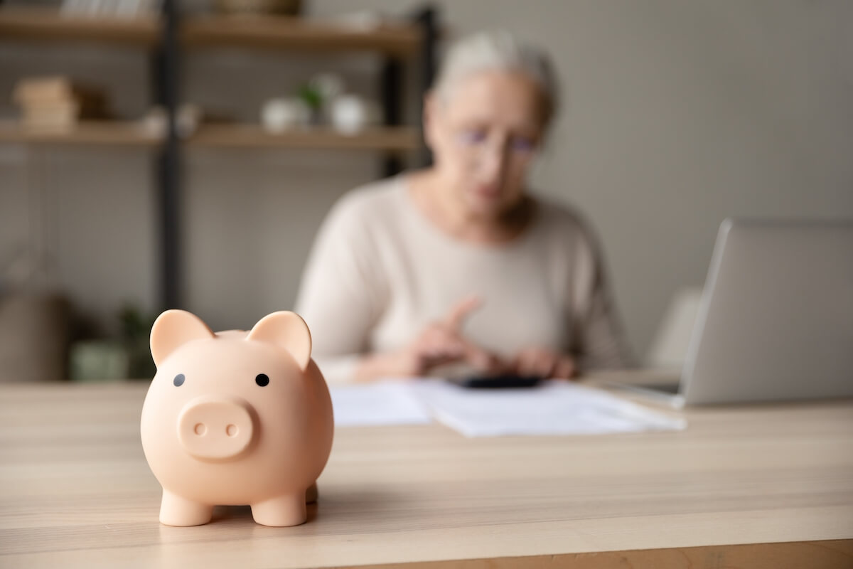 Older woman with a piggy bank navigating memory care costs