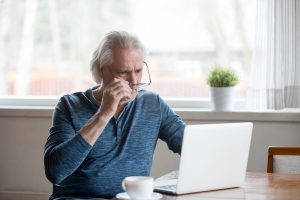 Senior taking a look at his laptop for memory care costs