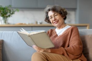 Older woman reading a book in senior living