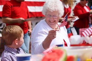 Older woman celebrating 4th of July with her grandson