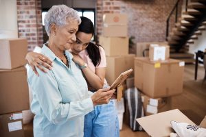 Older woman getting comforted by her adult daughter as she moves from home