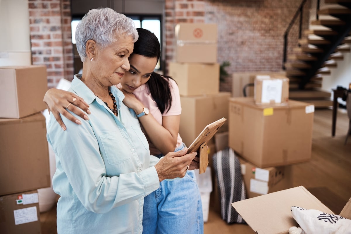Older woman getting comforted by her adult daughter as she moves from home
