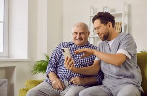 Caregiver showing a senior how to use tech