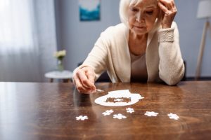 Older woman with a brain-shaped puzzle