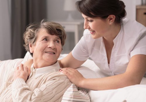 Caregiver comforting older woman